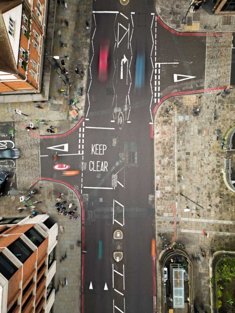 Top-down aerial of a busy city intersection marked KEEP CLEAR with blurred traffic
