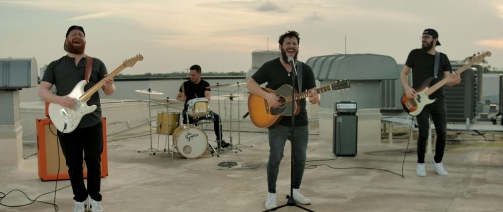 Kavana band performing on a rooftop at dusk during the 'Had It All' music video shoot