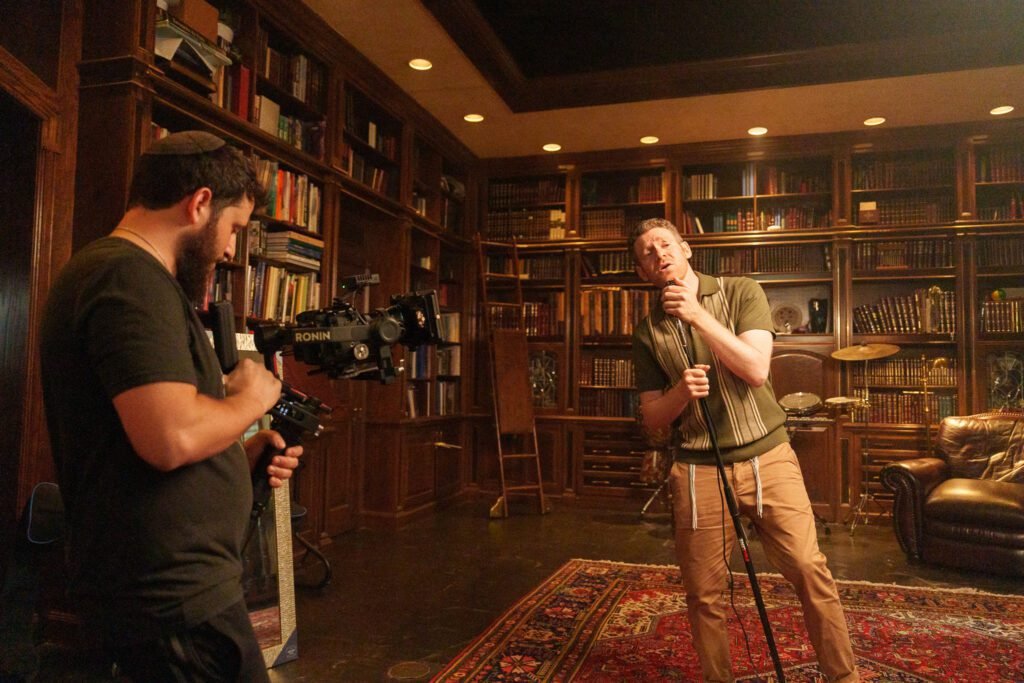 Dov Gurewicz filming a singer with a Ronin camera rig in a wood-paneled study
