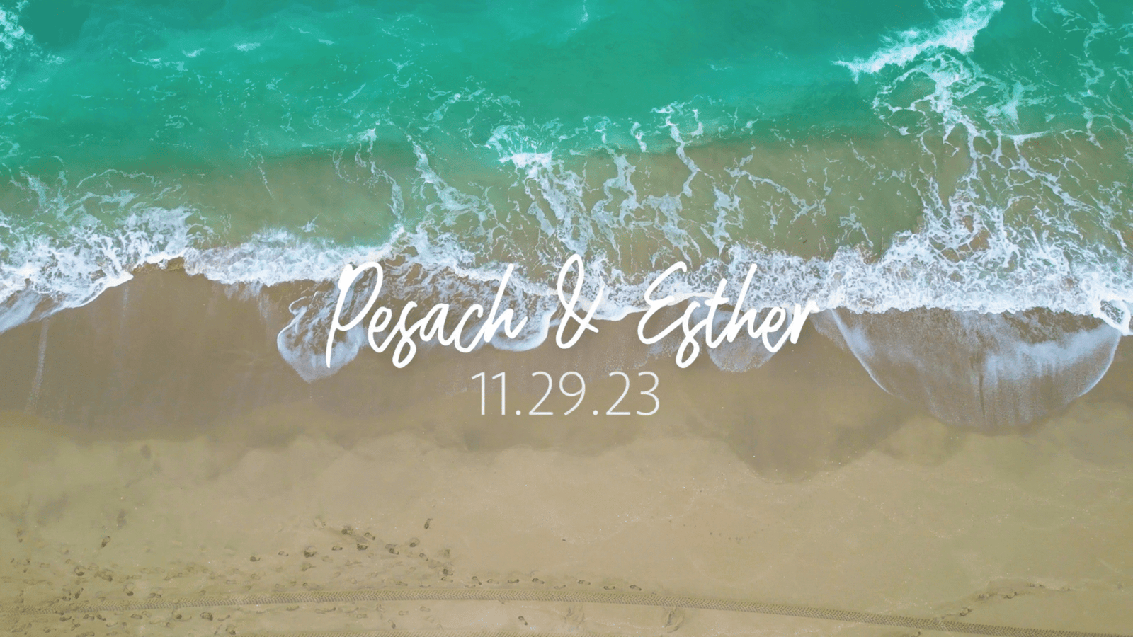 Overhead view of turquoise surf meeting sand with a couple's names and date in script