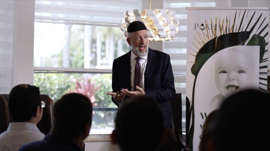 Video still of a speaker presenting at a community event