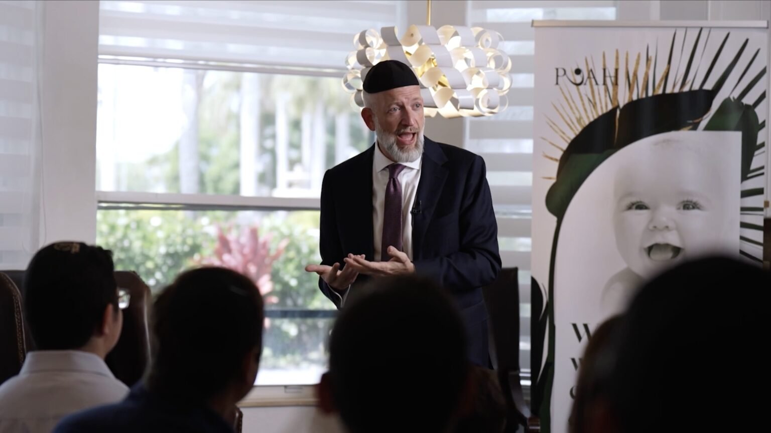Video still of a speaker presenting at a community event