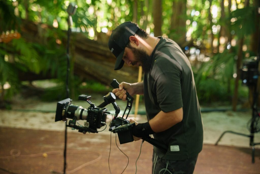 Videographer filming with a cinema camera rig in a forest setting