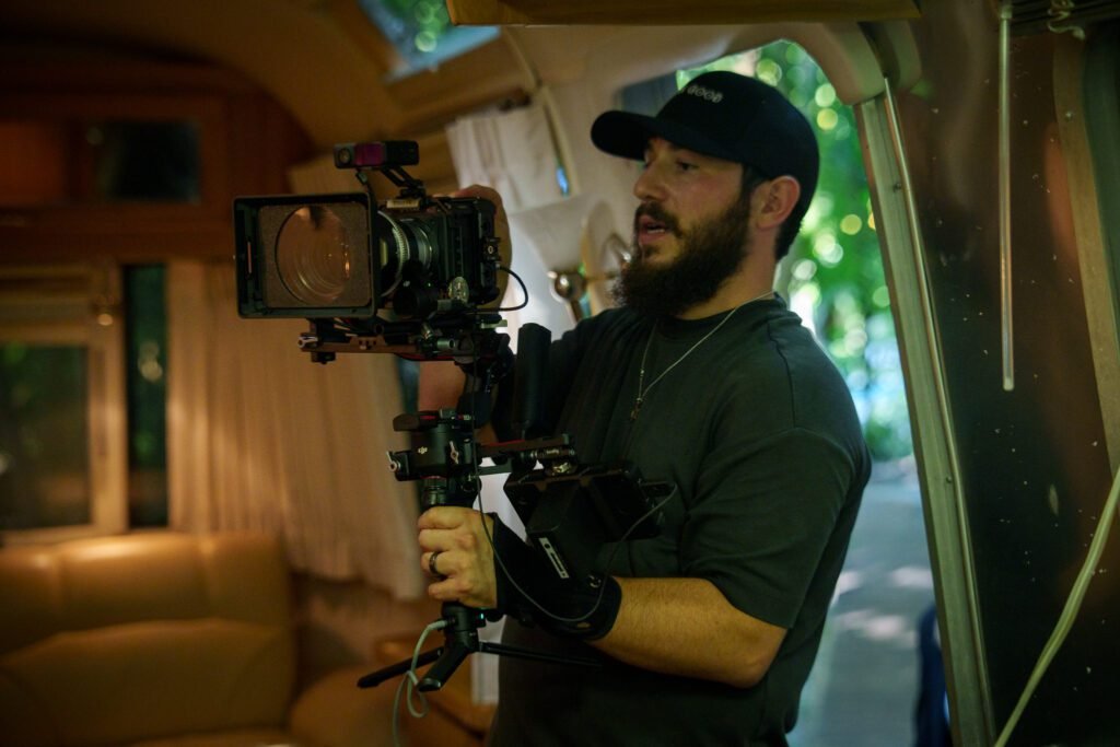 Dov Gurewicz filming with a cinema camera rig inside an Airstream trailer