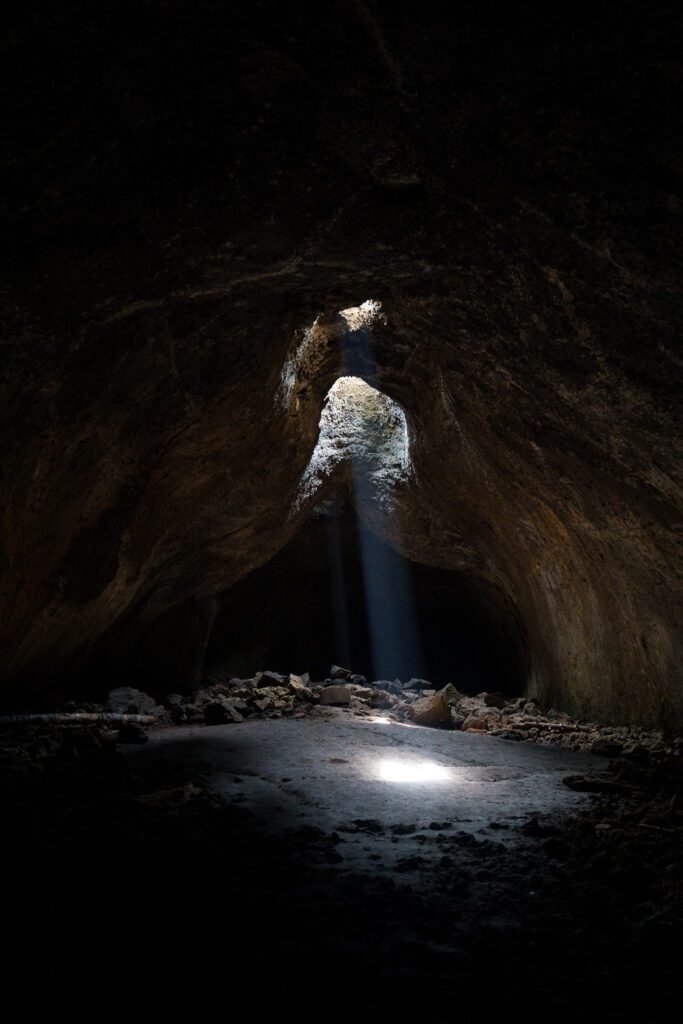 Shaft of daylight falling through a hole in the roof of a dark cave