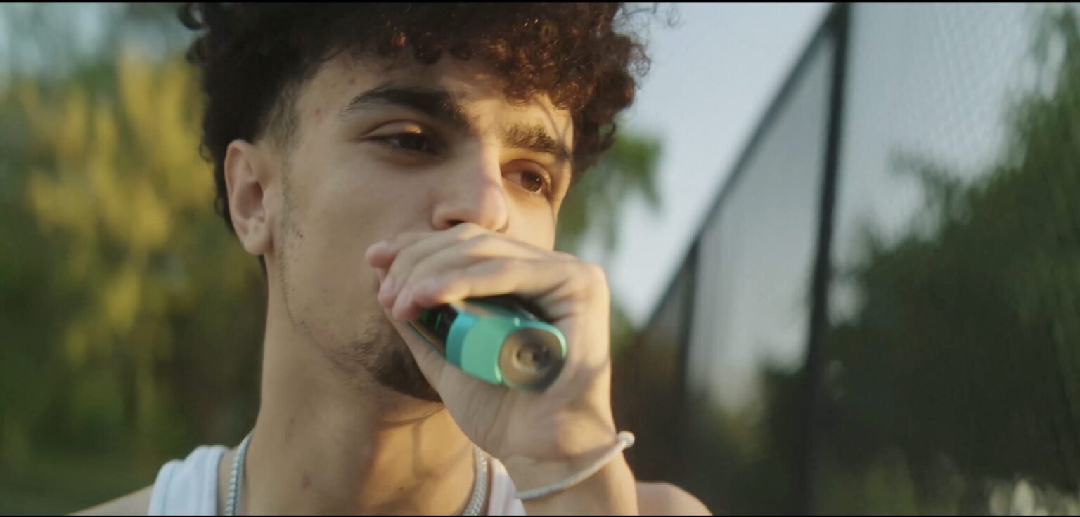 Young man smoking a vape outdoors