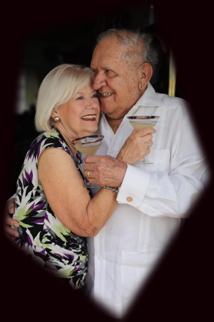 An older couple embracing and toasting with cocktails, a warm family celebration moment