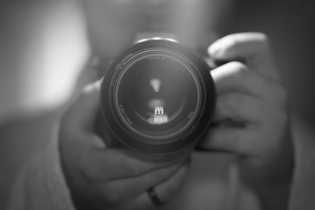 Person holding a camera, black and white