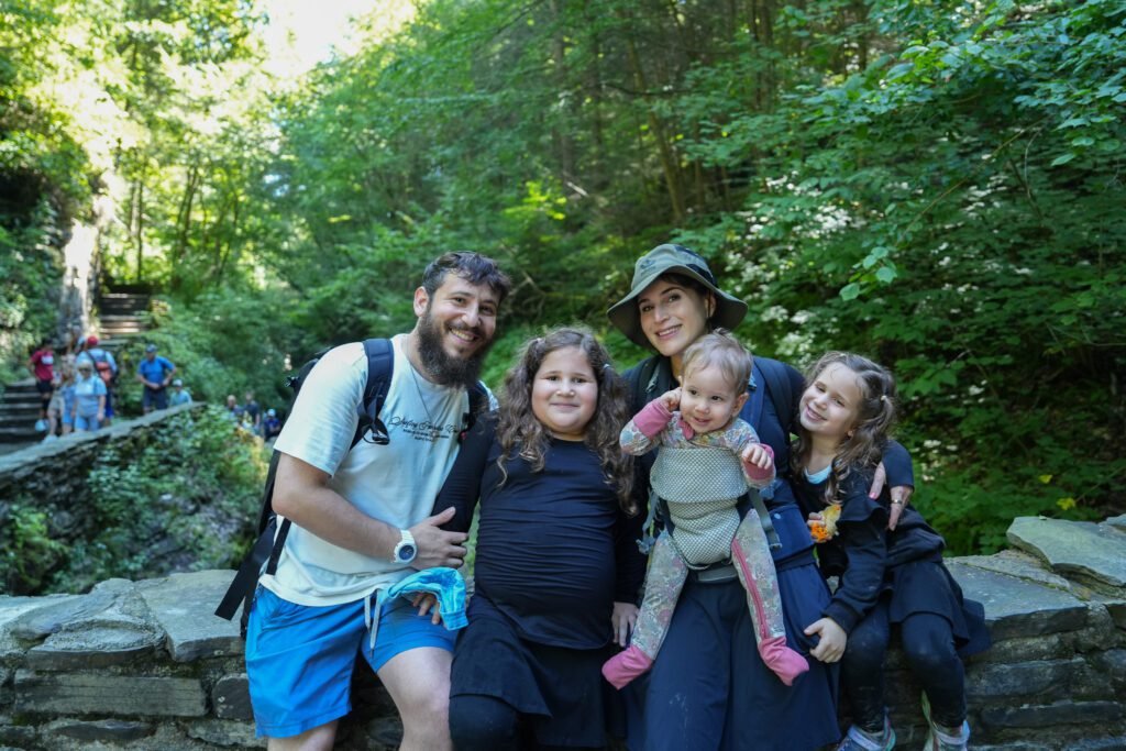 Dov Gurewicz with his wife and three children on a stone wall along the gorge trail at Watkins Glen