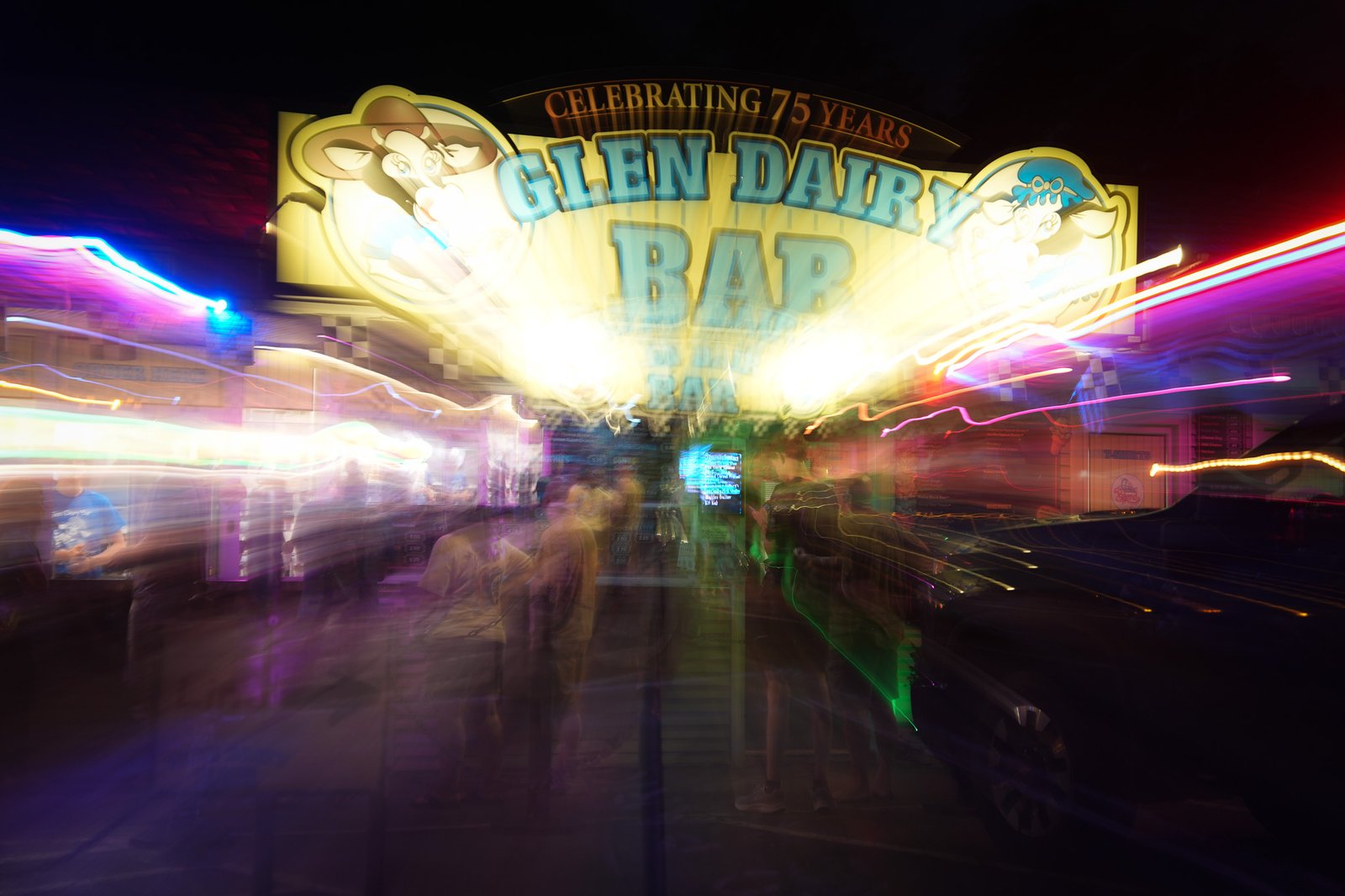 Neon sign of the Glen Dairy Bar in Watkins Glen at night, light streaked by a zoom exposure