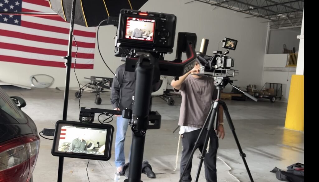 Crew filming the Doroni Aerospace brand film in the hangar beneath a large American flag