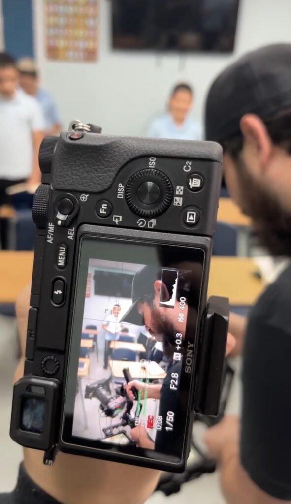 Camera screen showing an LEC classroom scene being filmed