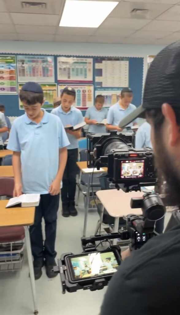 Filming LEC students standing at their desks with books open