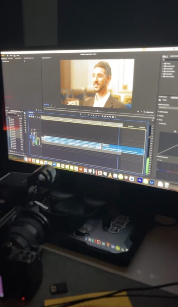 Edit timeline on a monitor showing an interview clip being cut