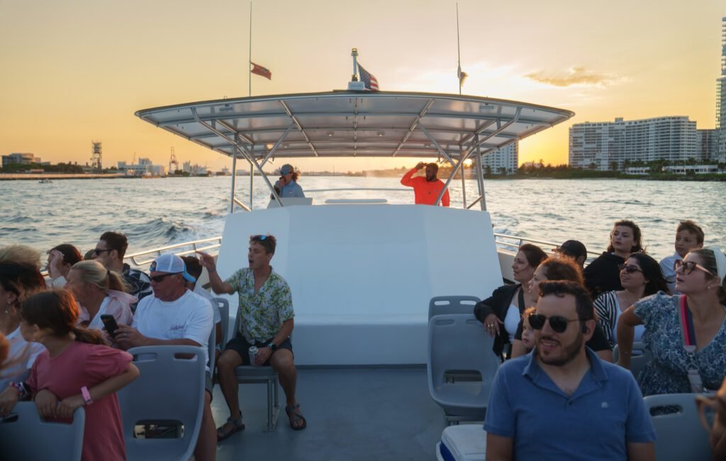 Sea Rocket sunset cruise boat full of passengers heading out with the Fort Lauderdale skyline on the horizon at sunset