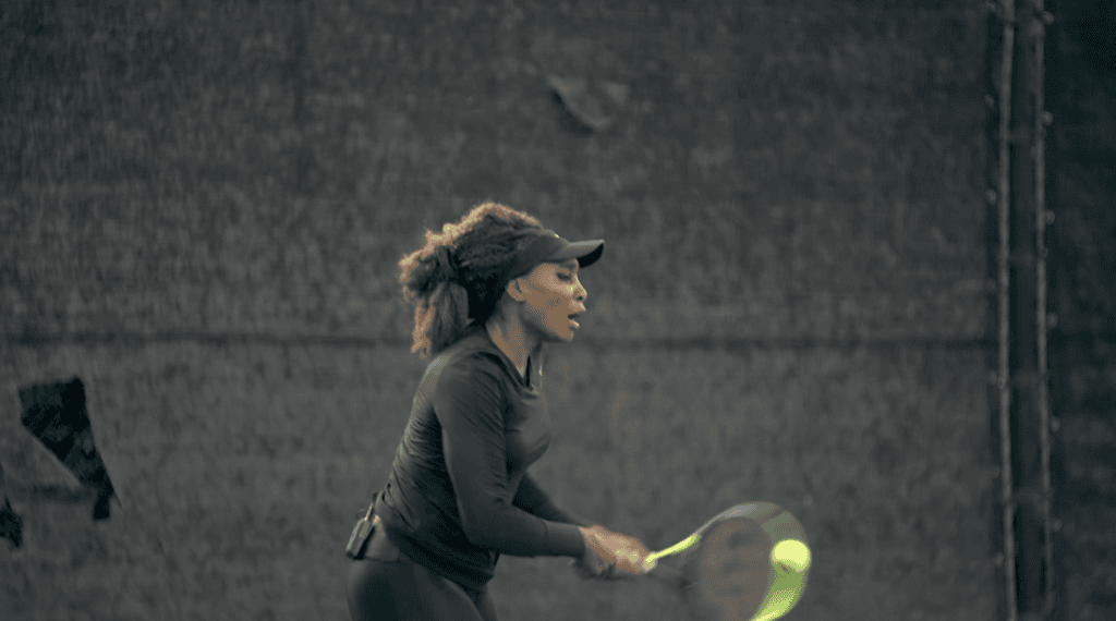 Venus Williams driving a two-handed backhand, the ball flattening against her strings