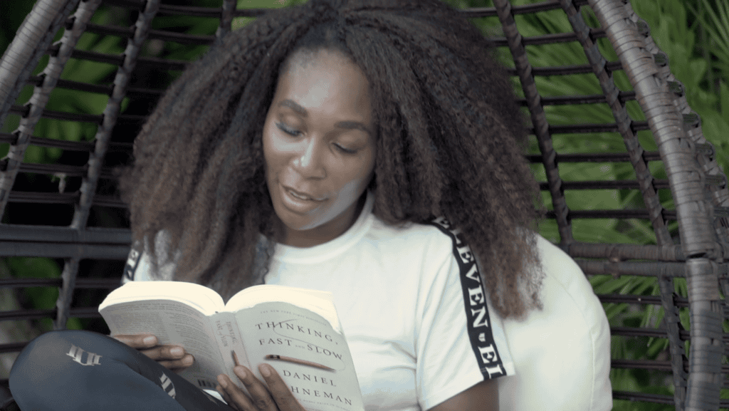 Venus Williams reading Thinking, Fast and Slow by Daniel Kahneman in a hanging chair in the garden